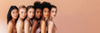 Group of multiracial women posing together against a beige background banner. Multiracial females standing together looking at camera and smiling. Multi-ethnic beauty. Different ethnicity. Copy space