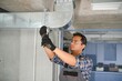 hvac indian worker install ducted pipe system for ventilation and air conditioning. copy space