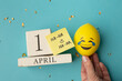 © яна винникова - April 1st. Image of april 1 wooden calendar and festive decor on the blue background. April Fool's Day