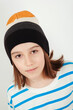 Cute boy wearing stylish woolen hat. Kid posing over white background.