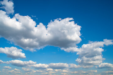 Wall Mural - Summer sky with low white clouds. Blue sky with clouds receding into perspective.