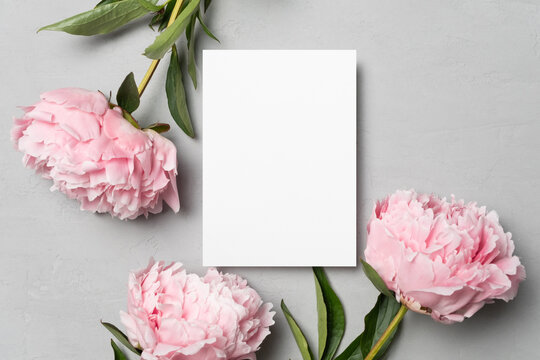 Invitation or greeting card mockup with peony flowers, flat lay with copy space