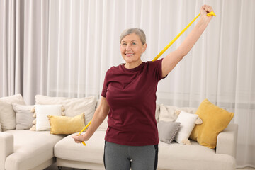 Sticker - Senior woman doing exercise with fitness elastic band at home