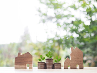 Poster - Miniature house and plants growing up on stack of coins. The concept of saving money for house, Property investment, House mortgage, Real estate.