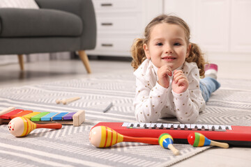 Poster - Little girl playing with toy musical instruments at home