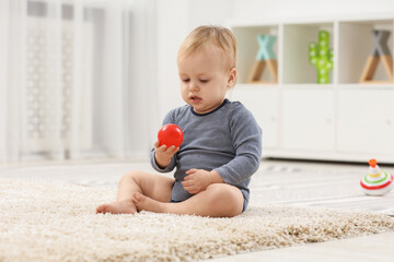 Sticker - Children toys. Cute little boy playing with red ball on rug at home