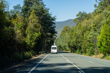 tourist traveling in a caravan exploring nature driving on a raod in the forest Cars Driving on a highway road, in australia