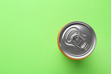 Wall Mural - Energy drink in can on green background, top view. Space for text