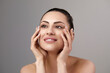 © verona_studio - Skin care. Woman with beauty face touching healthy facial skin portrait. Beautiful smiling girl model with natural makeup touching her skin