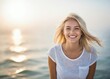 beautiful smile of young blonde girl   on a background of hazy sunshine through a thick mist on a calm sea 