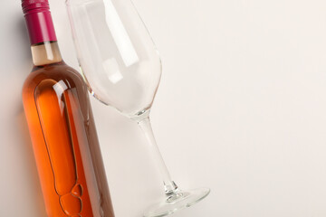 Poster - Bottle of expensive rose wine and wineglass on white background, top view. Space for text