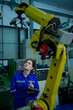 Female Robotics engineer working with Programming and Manipulating Robot Hand, Industrial Robotics Design