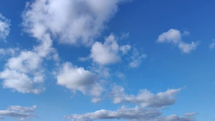 Wall Mural - small clusters of clouds move across the clear blue sky