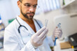© Mediteraneo - Male veterinarian working in laboratory. Vet doctor is examining sample at animal hospital. He is wearing uniform.