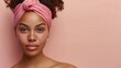 African American woman with curly hair against a beige background with a pink headband. Ideal skin, skin care products, beauty and health.