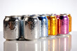 Striking array of colorful aluminum cans, covered in condensation droplets, lined up against a reflective surface, showcasing a vibrant palette