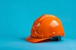 Orange worker helmet on a blue background. International Labor Day, Workers Day, May Day concept. Design for banner, poster with copy space