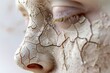 Close up of a person's face covered in mud. Suitable for skincare or outdoor activities concept.