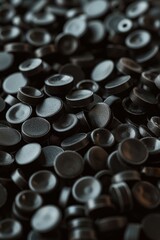 Poster - A pile of black buttons on a table, suitable for fashion design projects.