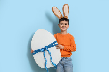 Sticker - Cute little boy with bunny ears and big Easter egg on blue background