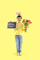 Sticker - Cute little boy in bunny ears holding tulip flowers and chalkboard with text HAPPY EASTER on yellow background