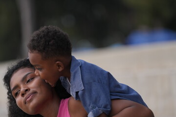 Wall Mural - Mixed race African and Asian mother and boy is playing at the outdoor area. smiling happy family have fun running on the beach. portrait of mom and kid lifestyle with a unique hairstyle.