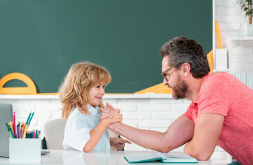 Fototapete - Teacher play with child student pupil from elementary school in classroom. Father and son boy at school.