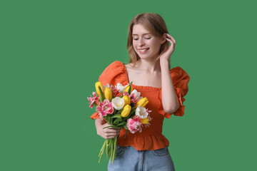 Wall Mural - Pretty young woman with bouquet of beautiful tulips on green background