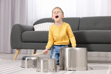 Wall Mural - Little boy pretending to play drums on pots at home