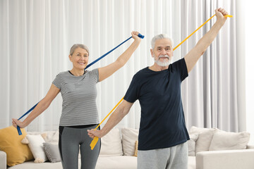 Sticker - Senior couple doing exercise with fitness elastic bands at home