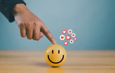 Wall Mural - hand with happy smiley face emotion on wooden circle. customer service satisfaction, positive thinki