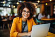 © nao - happy young businesswoman in yellow suit looking at camera smile in the cafe using laptop