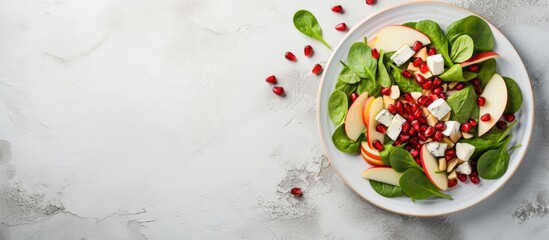 Poster - A dish of spinach, apples, feta cheese, and pomegranate seeds served on a white plate, showcasing a mix of food ingredients and plantbased cuisine