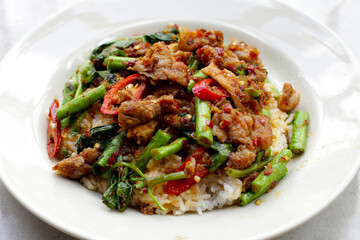 Wall Mural - Rice with spicy stir fried pork and yard long bean with red curry paste. Thai food