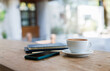 © Lek - Latte coffee with mobile and note book on wooden table in outdoor cafe