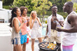Diverse group of friends enjoys a barbecue party outdoors
