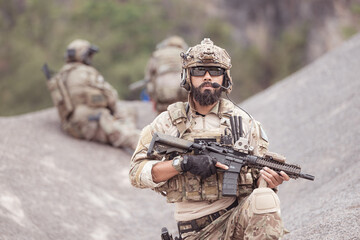 Soldiers in camouflage military uniforms carrying weapons, Reconnaissance missions in rugged mountains, Assault infantry battle training.