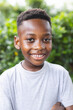 © Wavebreak Media - African American boy with a bright smile stands outdoors in a garden