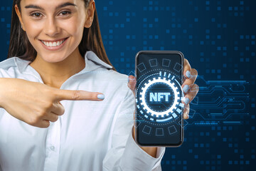 Aufkleber - Attractive happy young woman pointing at smartphone with creative round nft hologram on digital blue background. Non-fungible token and digital blockchain artwork concept.