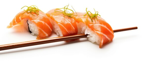 Canvas Print - A close up of sushi with chopsticks on a white background. This dish features California roll, a popular sushi recipe made with fresh ingredients and tableware designed for Japanese cuisine