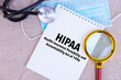 © Iryna - HIPAA, the Health Insurance Portability and Accountability Act of 1996, text written on white notepad, medical mask, stethoscope, magnifying glass on linen background.