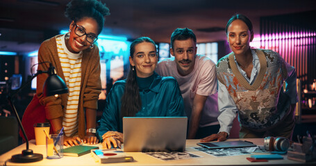 Poster - Posing Shot of a Diverse Group of Talented Young Business People Gathered Around a Desk in a Modern Creative Office, Brainstorming. Multiethnic Teammates Looking at Camera and Smiling