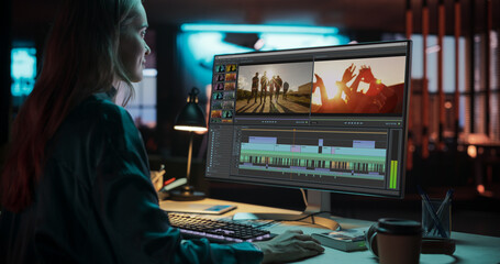 Fototapete - Portrait of Female Videographer Working on a Film on Her Desktop Computer. Focused Woman Making a Video Montage and Design for a Clip in Creative Office at Night