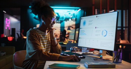 Aufkleber - Female Talented Digital Marketing Specialist Working on Computer at Office in the Evening. Young Black Businesswoman in Creative Agency, Smiling and Researching Business Analytical Data