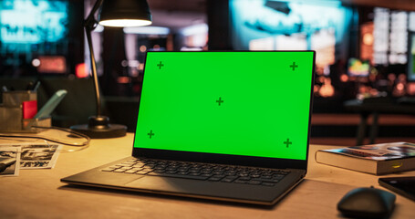 Leinwandbilder - Laptop Computer Standing on a Wooden Desk with a Green Screen Chromakey Mock Up Display. Creative Office Working Station for Game Developer and Graphic Designer in Creative Agency