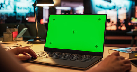Leinwandbilder - Anonymous Designer Working on a Laptop Computer with Mock Up Green Screen Chromakey Display with Isolated Placeholder. Video Template for Artistic Content Creation and Presentations