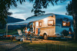 © Fxquadro - A family enjoys a peaceful evening outside their recreational vehicle surrounded by nature's calm