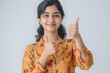 © john - A portrait of a 24-year-old smart Indian collage girl, Confidently standing and showing thumb-up directly at the camera with her right hand, giving a sure gesture, Captured at a slight side angle whil