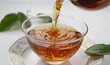 Tart, aromatic tea with a rich infusion and taste pours into a cup close-up on a white background