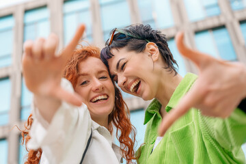 smiling young women girlfriends having a fun time together, talking and using phones, shopping outdo